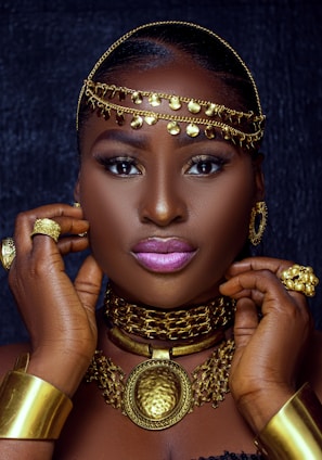 a woman wearing gold jewelry and a head piece
