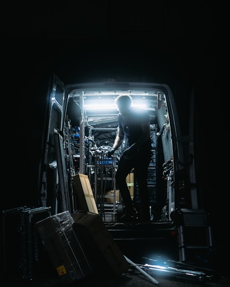 a man standing in the back of a truck in the dark