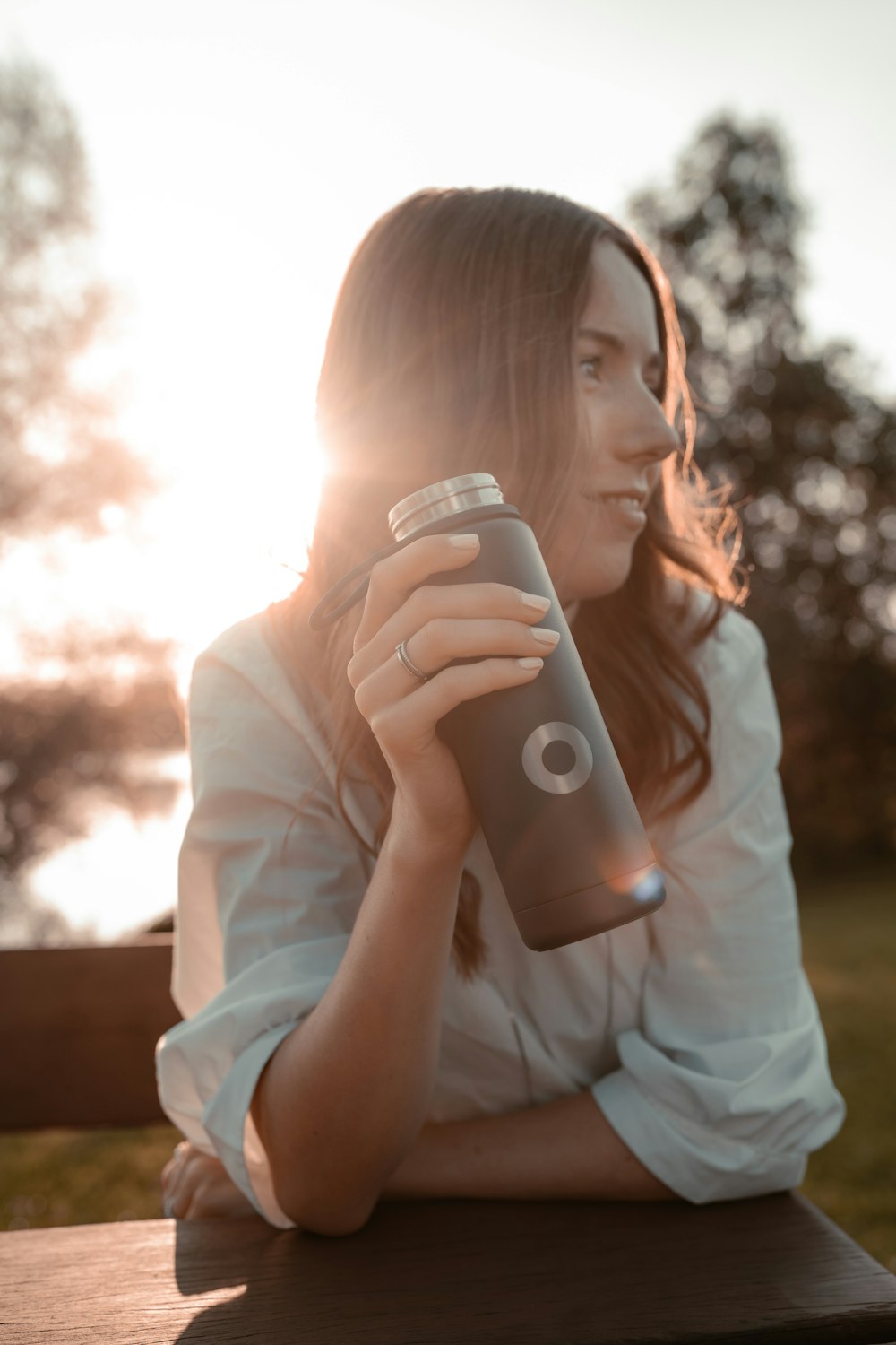 a woman sitting on a bench holding a camera