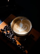 a cup of coffee with a leaf on top of it