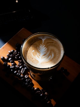 a cup of coffee with a leaf on top of it