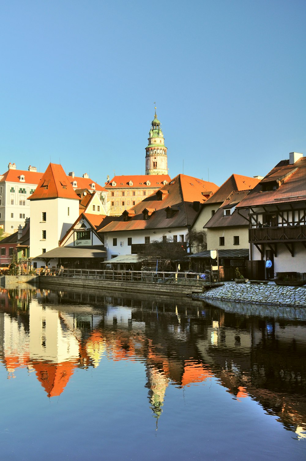 a river with buildings and a clock tower in the background