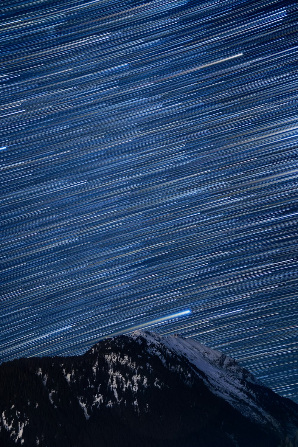 the night sky with a mountain in the background