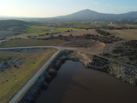 Wide shot of large-scale parcels surrounded by mountainous terrain with dirt roads in place.