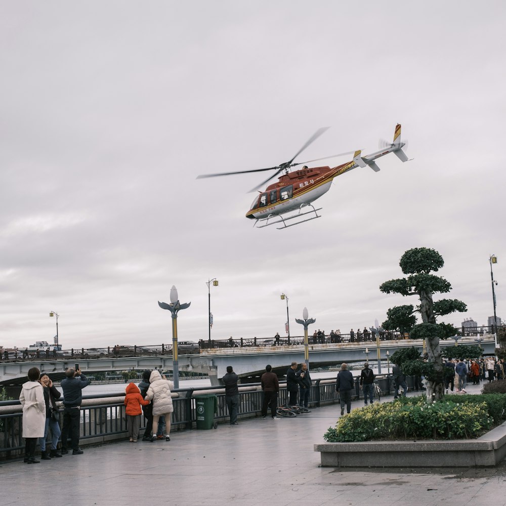 a helicopter is flying over a group of people