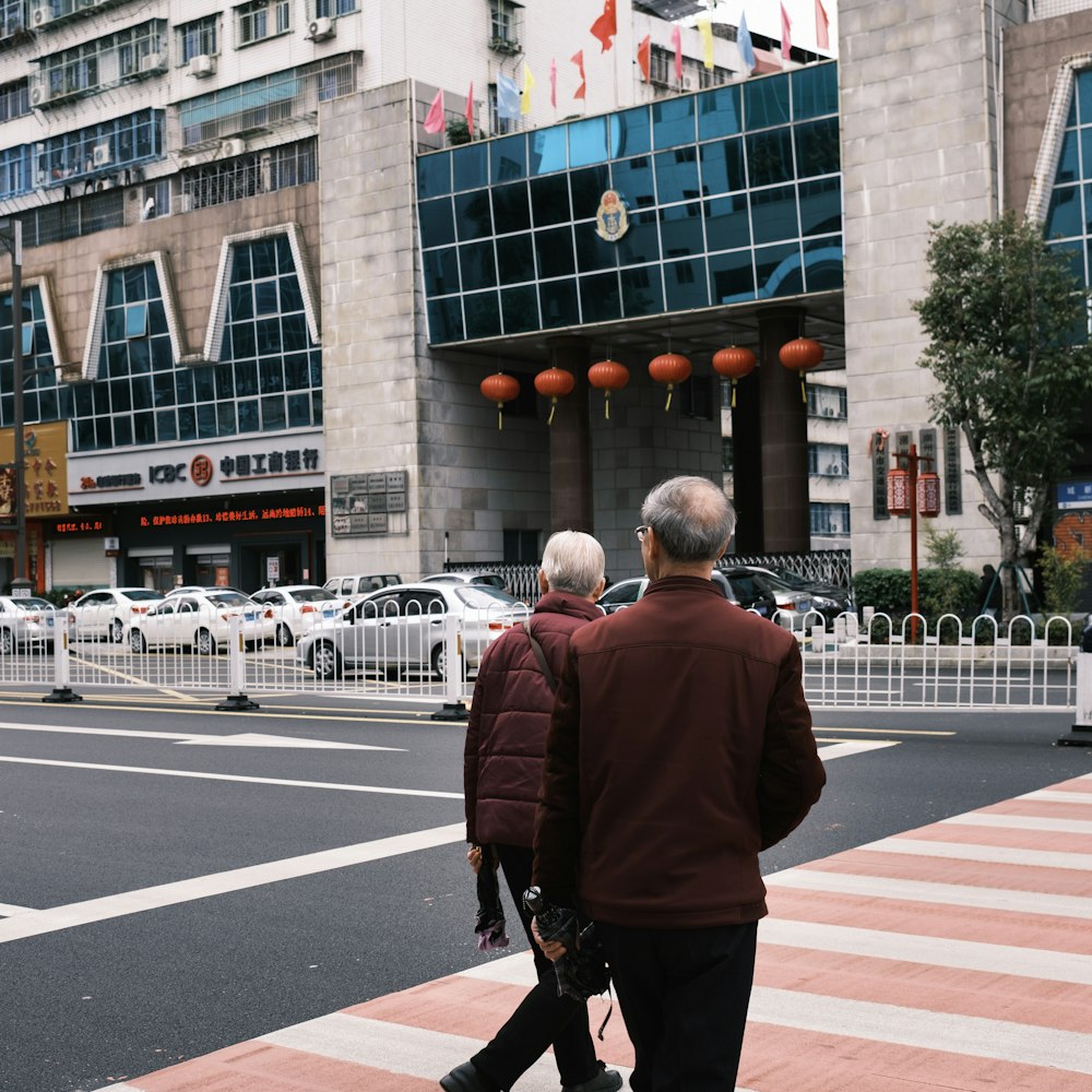 a couple of people that are walking across a street