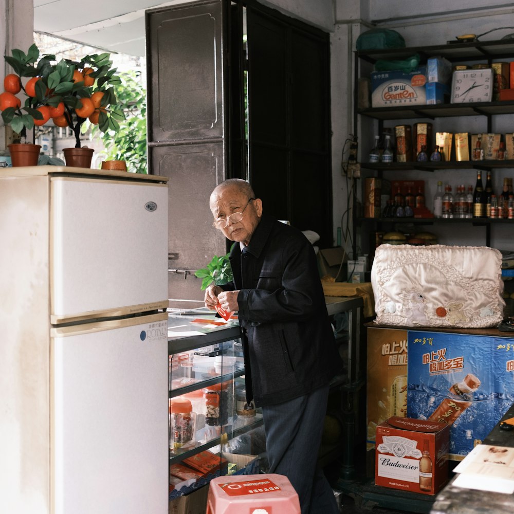 a man standing next to a refrigerator in a kitchen