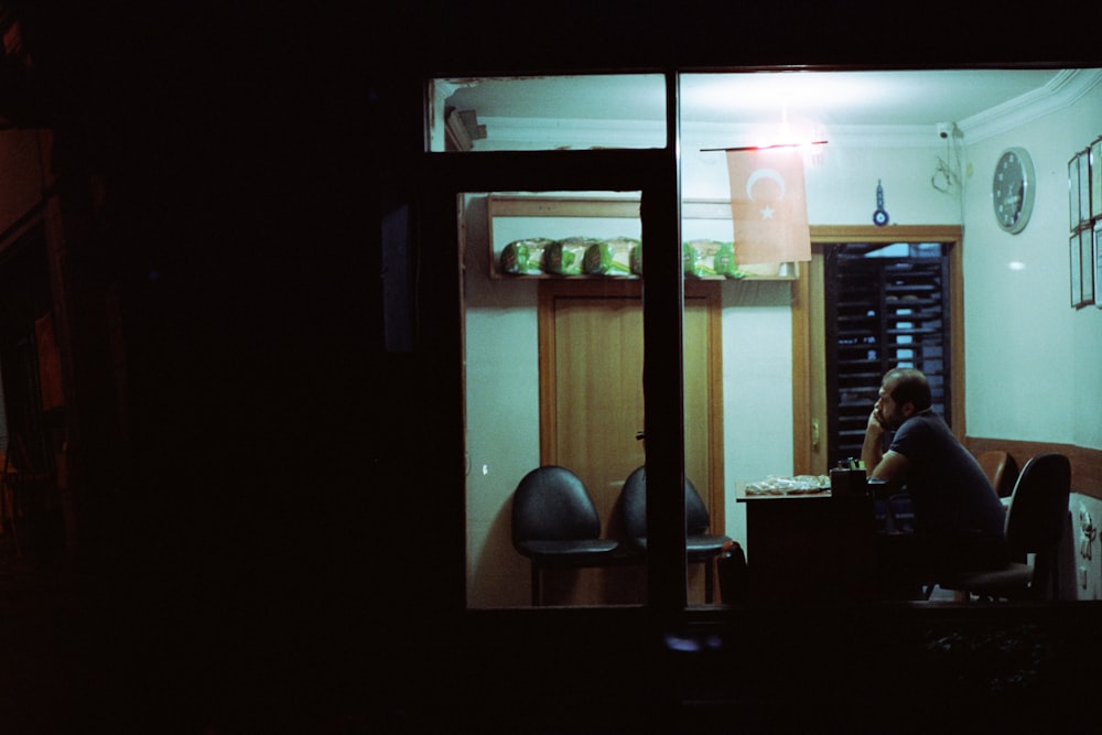 a person sitting at a table in a dark room