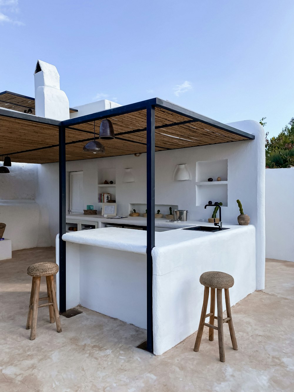 an outdoor kitchen with a bar and stools