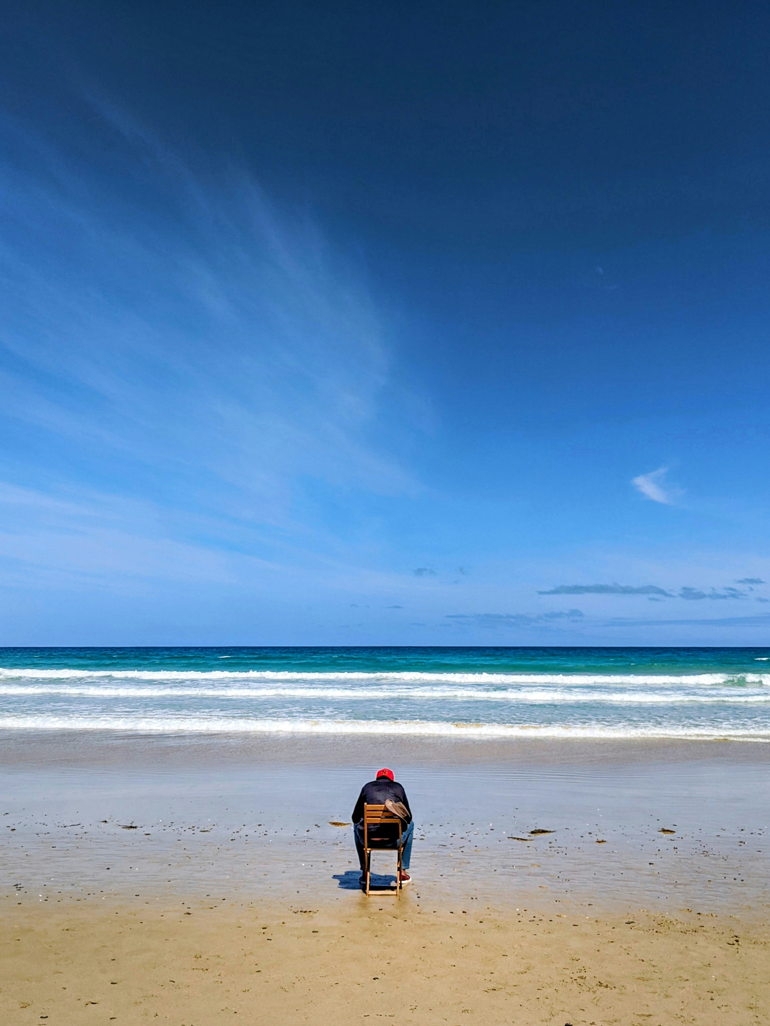 a person sitting on a bench on a beach