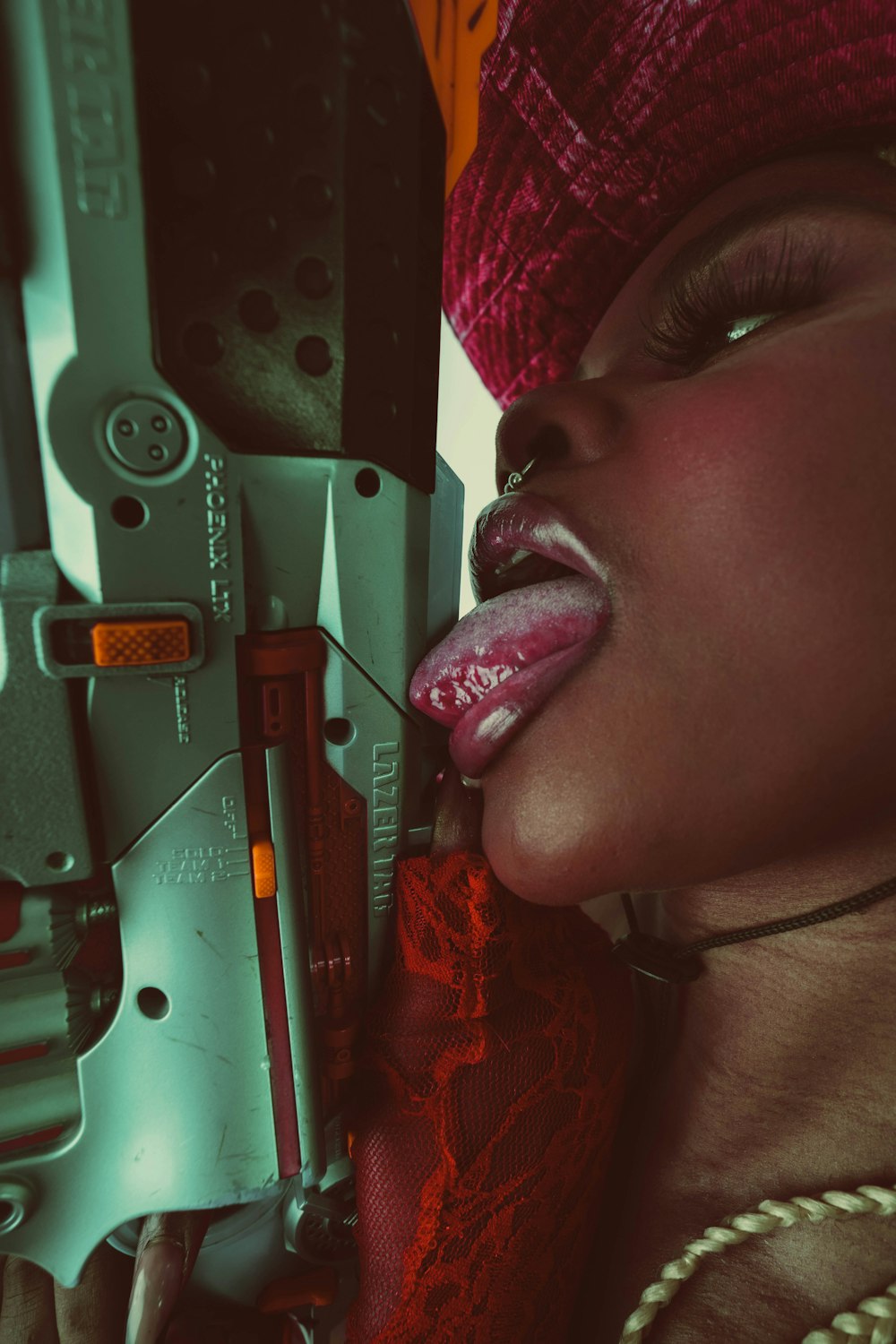 a woman with a gun sticking her tongue out