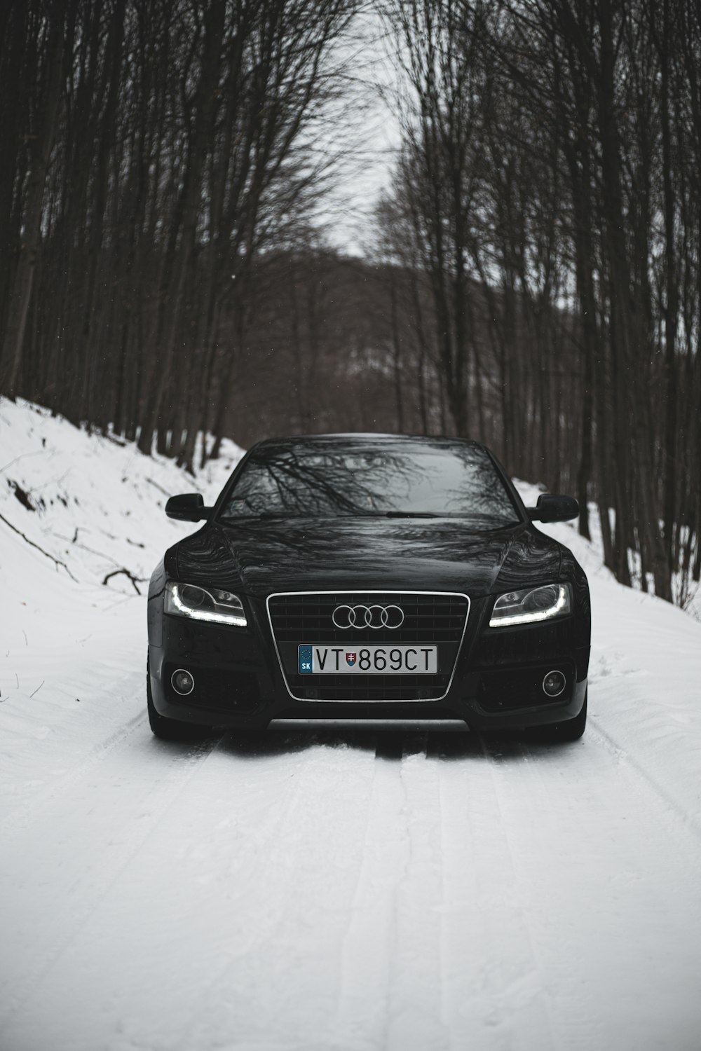 a black car parked on a snowy road
