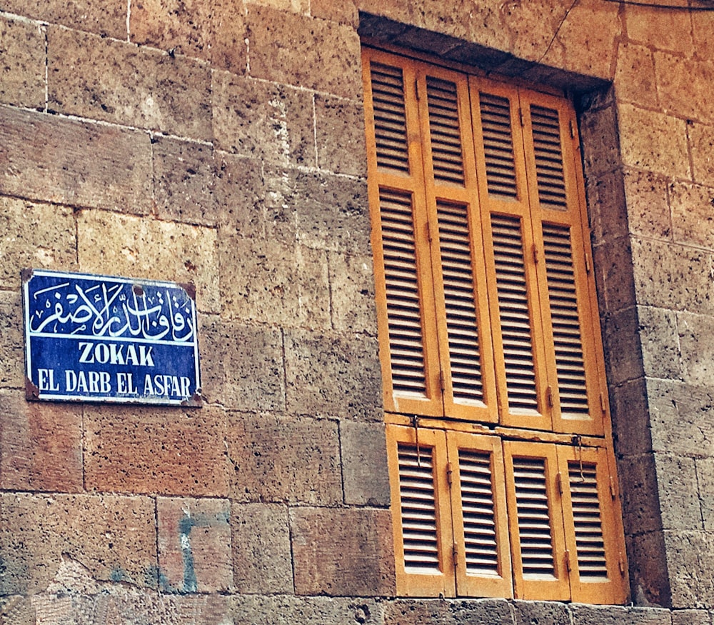 uma placa de rua azul montada ao lado de um edifício