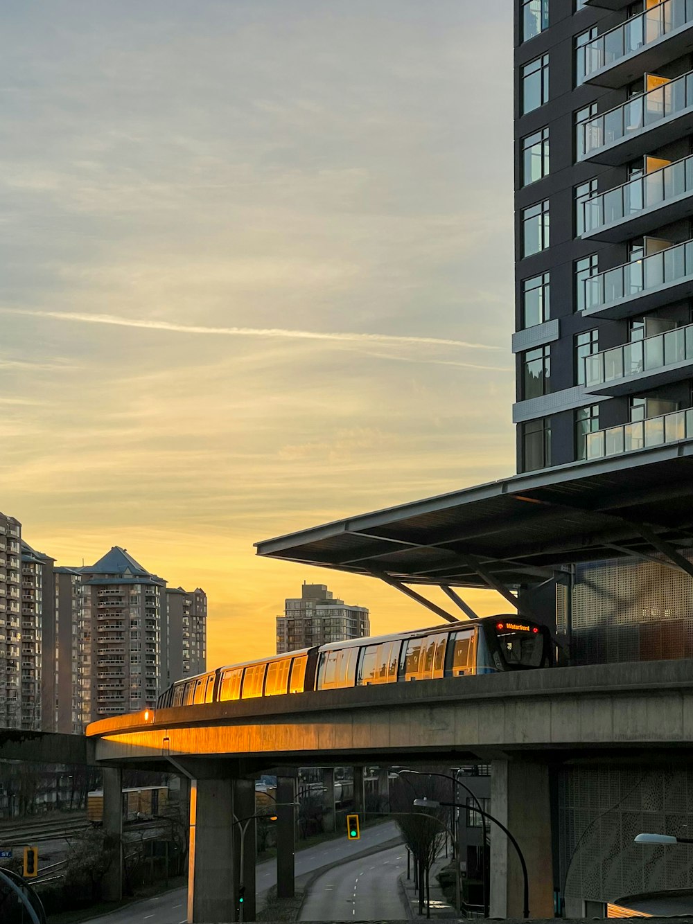 a train traveling over a bridge next to tall buildings