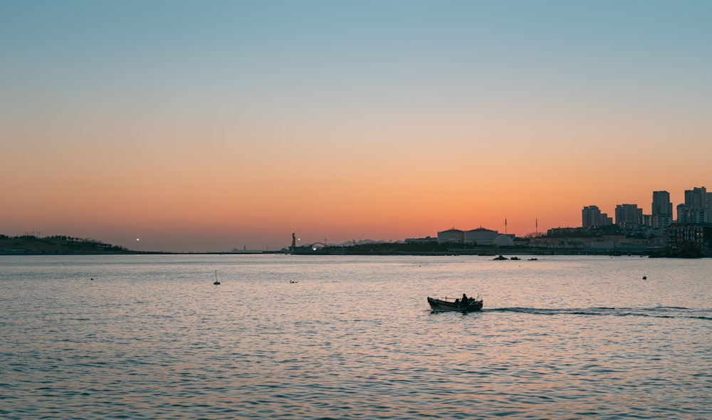 a small boat in the middle of a large body of water