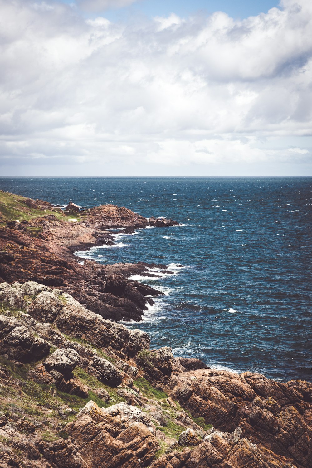 a view of the ocean from a rocky cliff