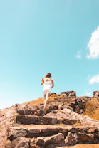 a woman running up some steps on a sunny day