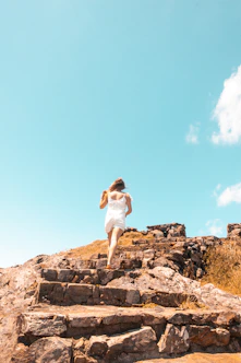 a woman running up some steps on a sunny day