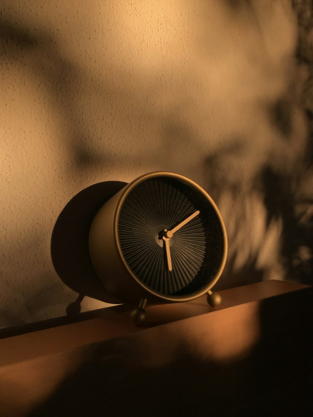 un orologio seduto in cima a una mensola di legno