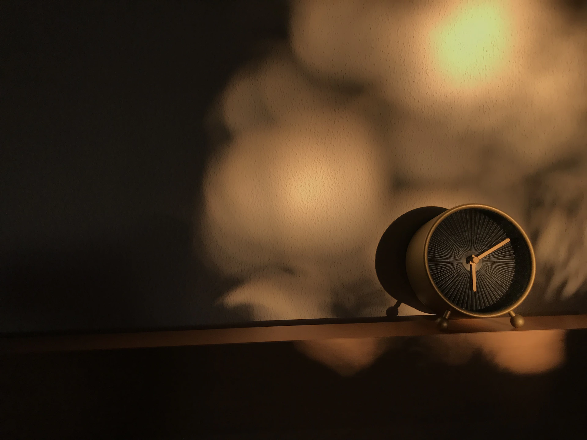a clock sitting on top of a wooden shelf