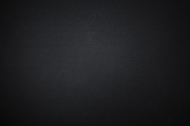 A plain, textured dark surface with a subtle grainy pattern.