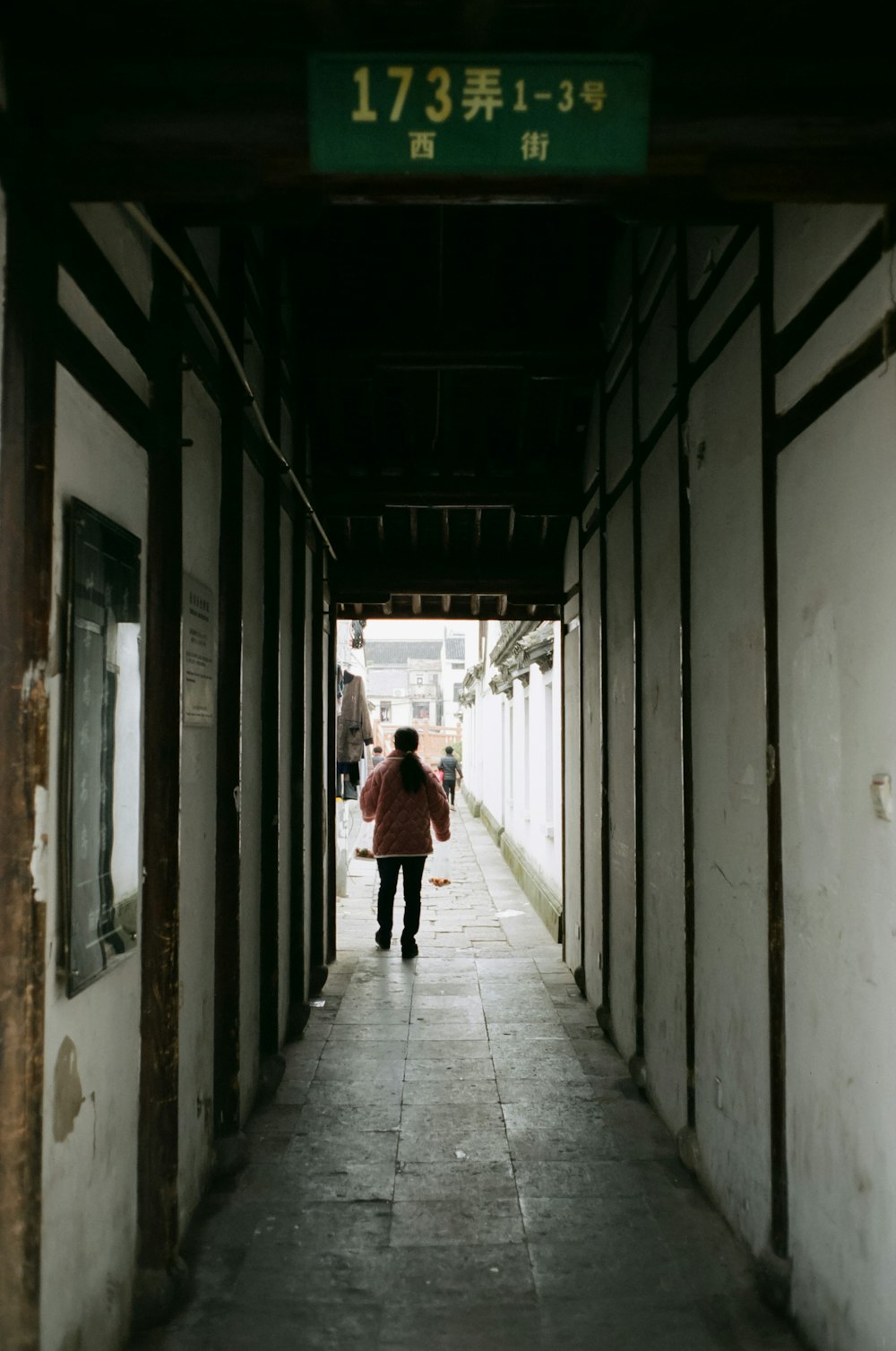 a person walking down a long hallway in a building