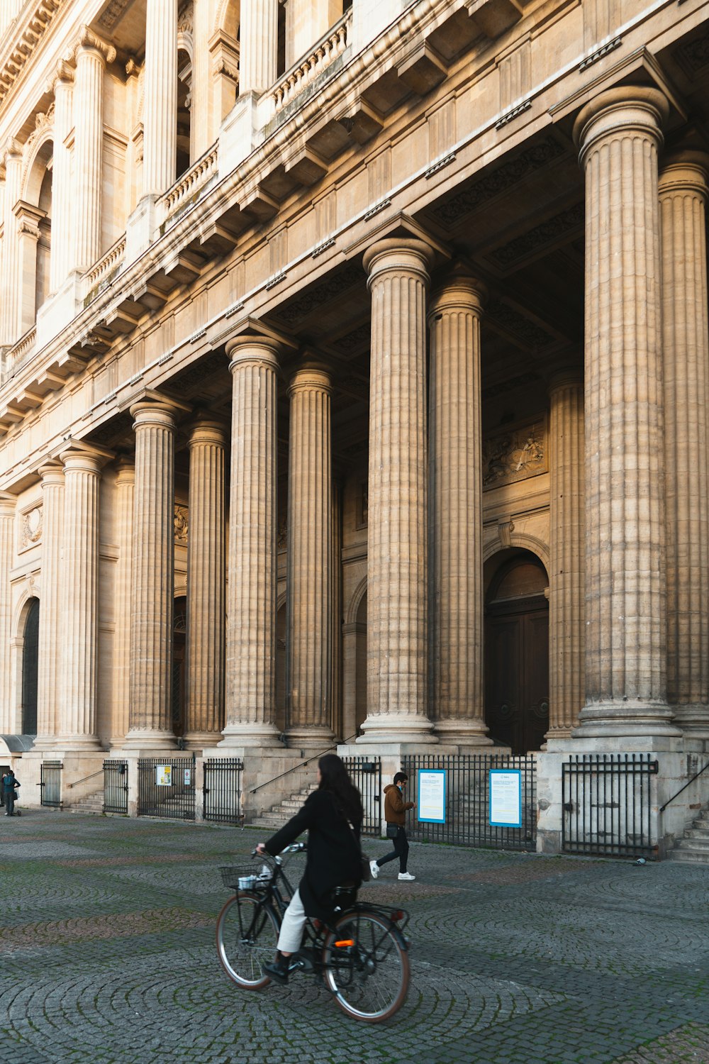 a person riding a bike in front of a building