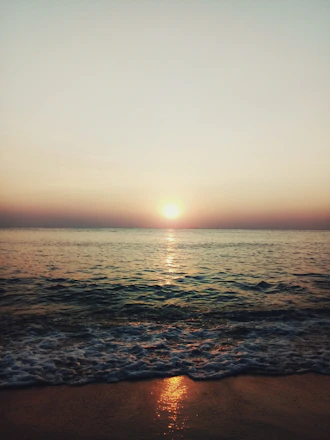 A serene sunset over the Atlantic coast with waves gently crashing on the shore.