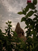 Ancient stone temple framed by vibrant autumn foliage in Uttarakhand