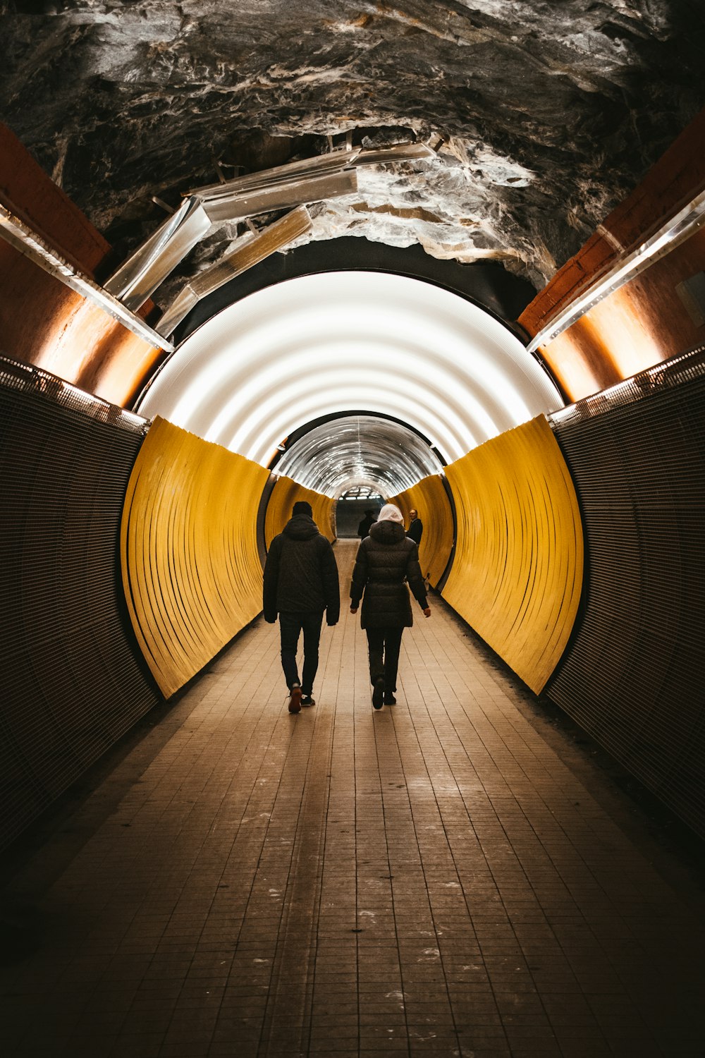 Un couple de personnes qui marchent dans un tunnel