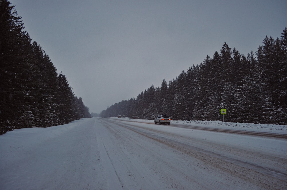 a car driving down a snow covered road