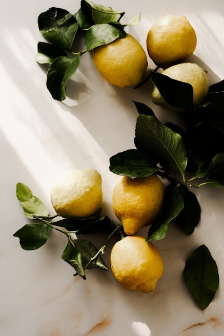 Bright yellow lemon wedges arranged on a soft green surface with gentle natural light