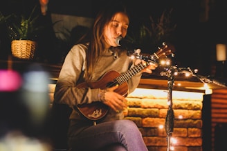 a woman sitting on a bench playing a guitar