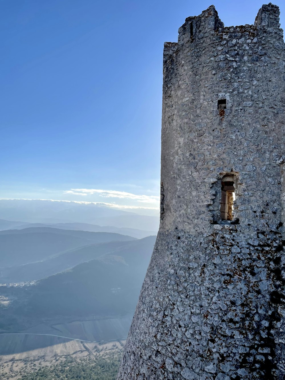 a stone tower with a window on top of it