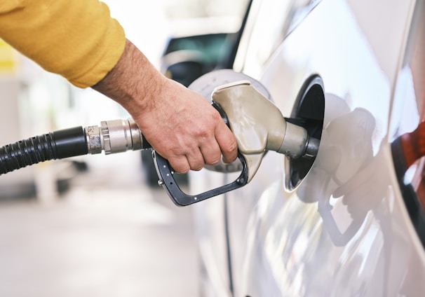 a man pumping gas into his car at a gas station