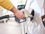 a man pumping gas into his car at a gas station