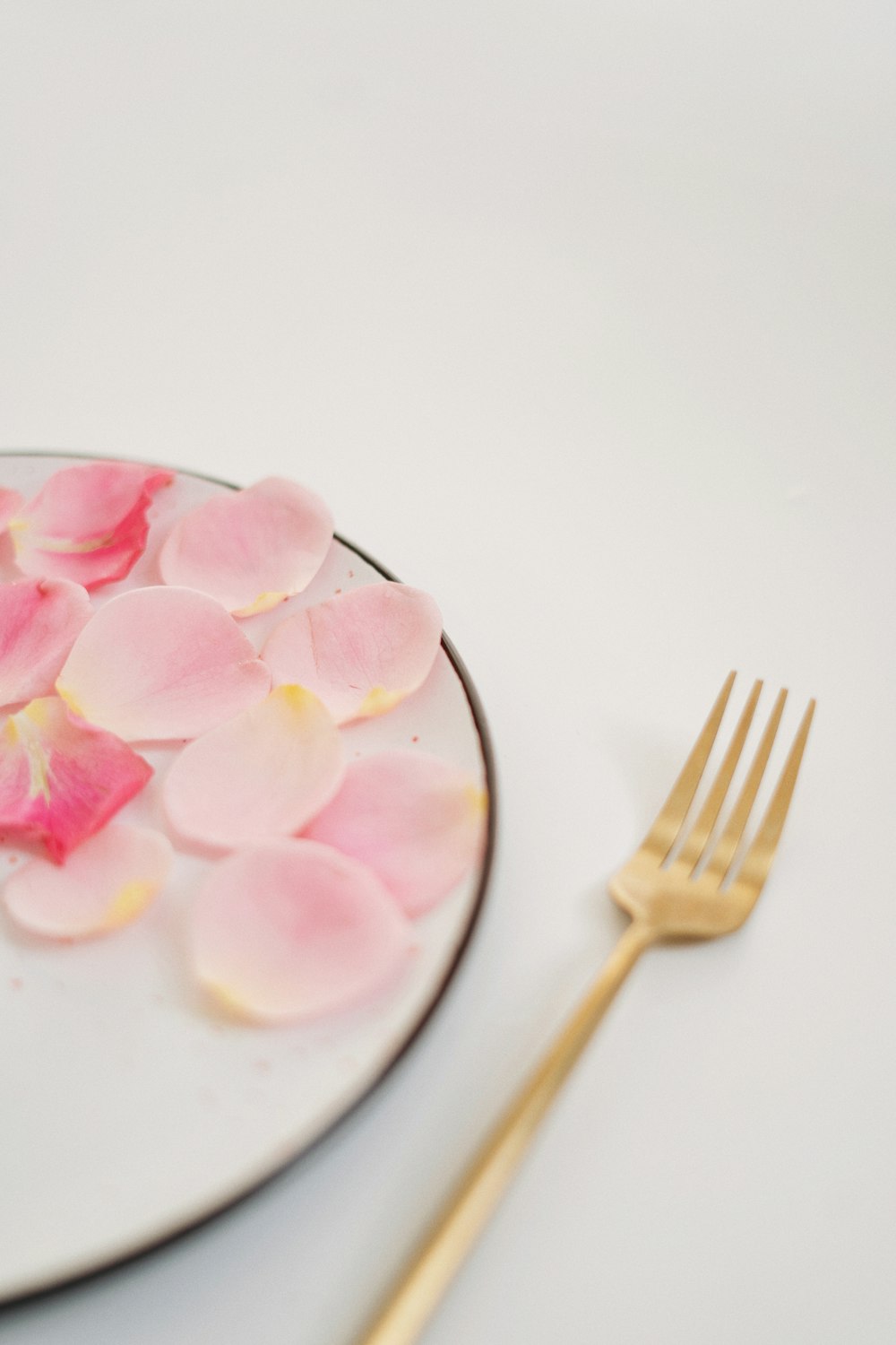 a white plate topped with pink flowers next to a fork