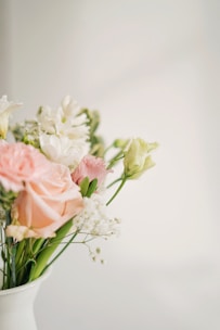 A bouquet of pastel pink and white flowers arranged elegantly in a vase