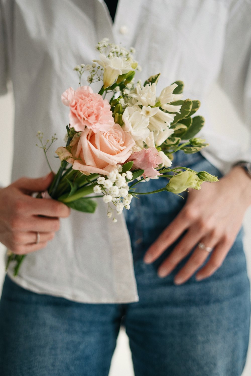 a woman holding a bouquet of flowers in her hands