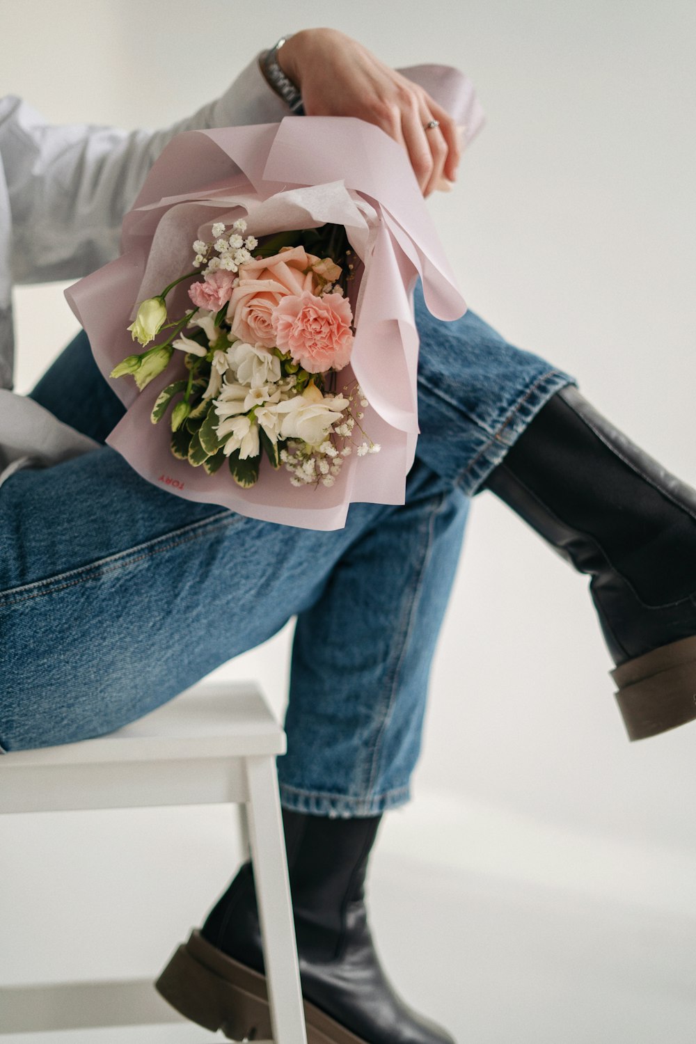 a woman sitting on a chair holding a bouquet of flowers