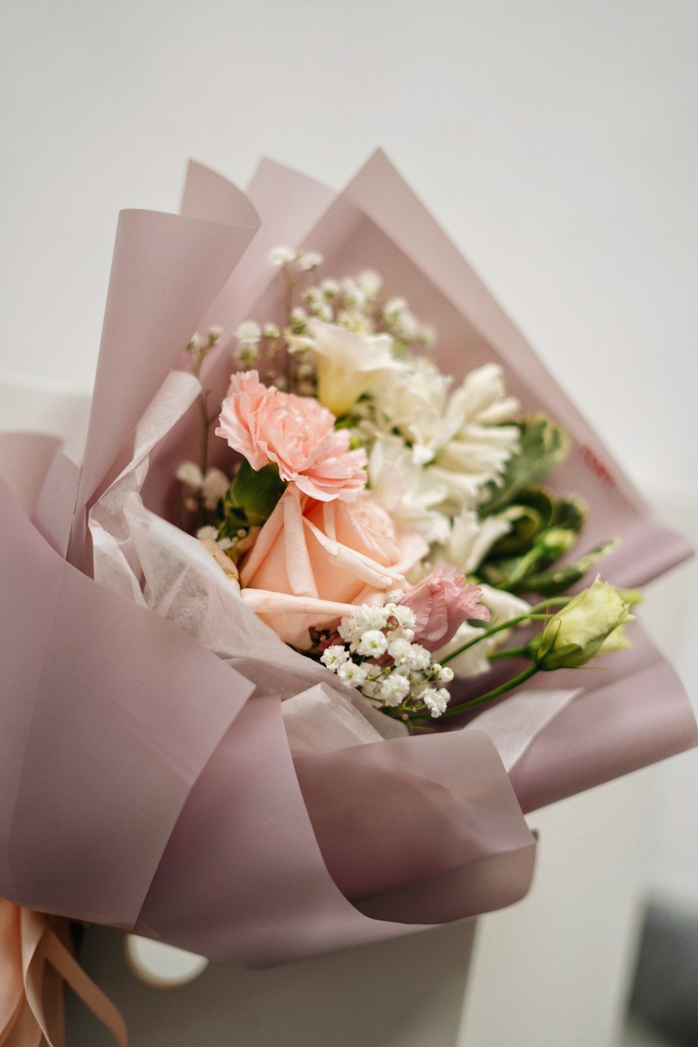 a bouquet of flowers is wrapped in pink paper