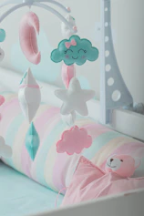 a baby crib with a teddy bear and a cloud mobile