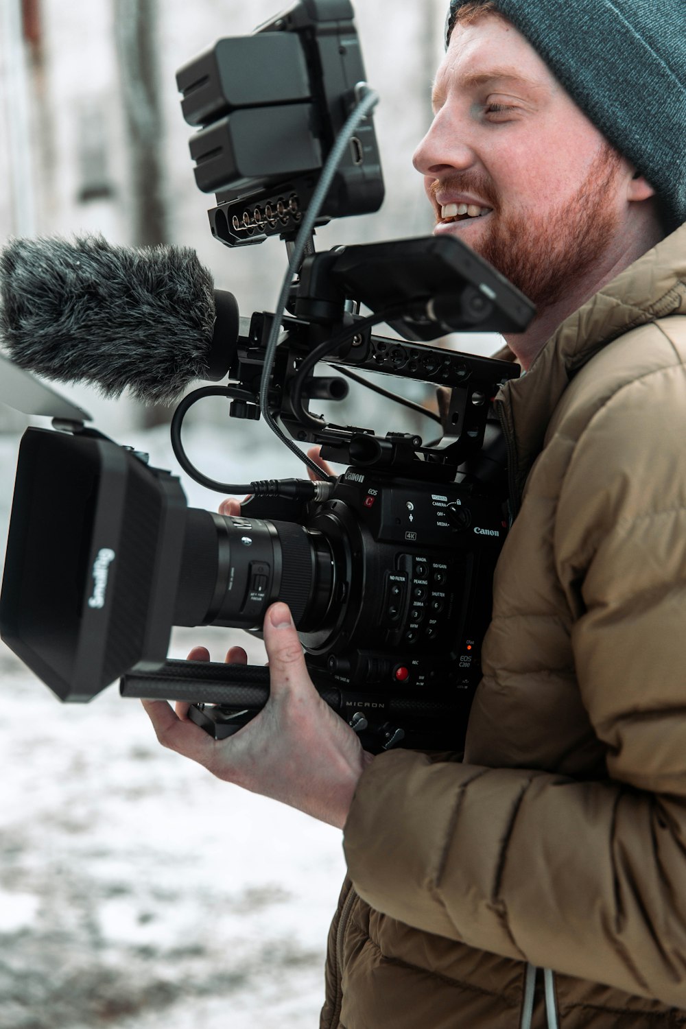 a man holding a camera with a microphone attached to it