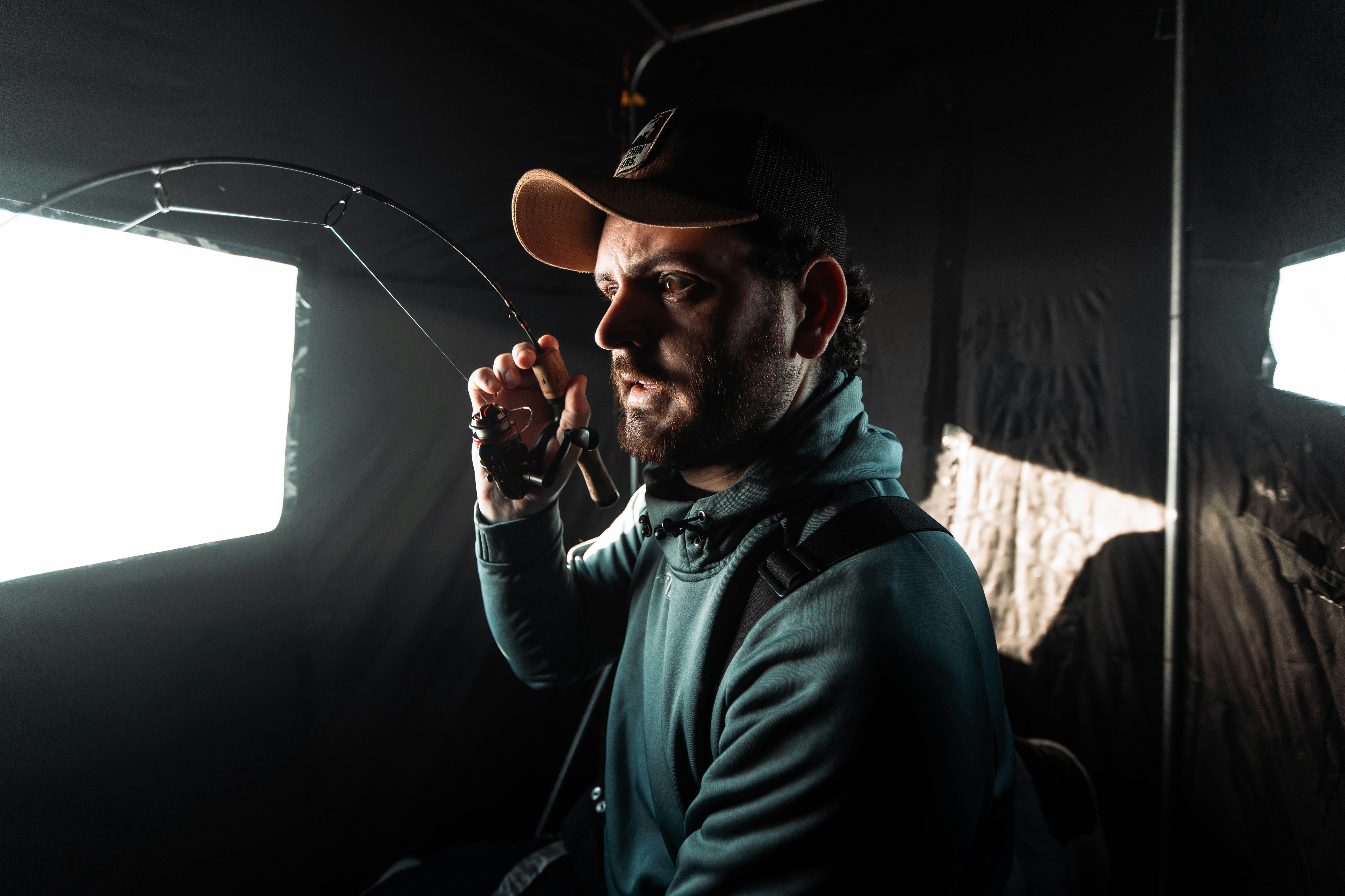 Ein Mann mit Hut und Angelrute in der Hand