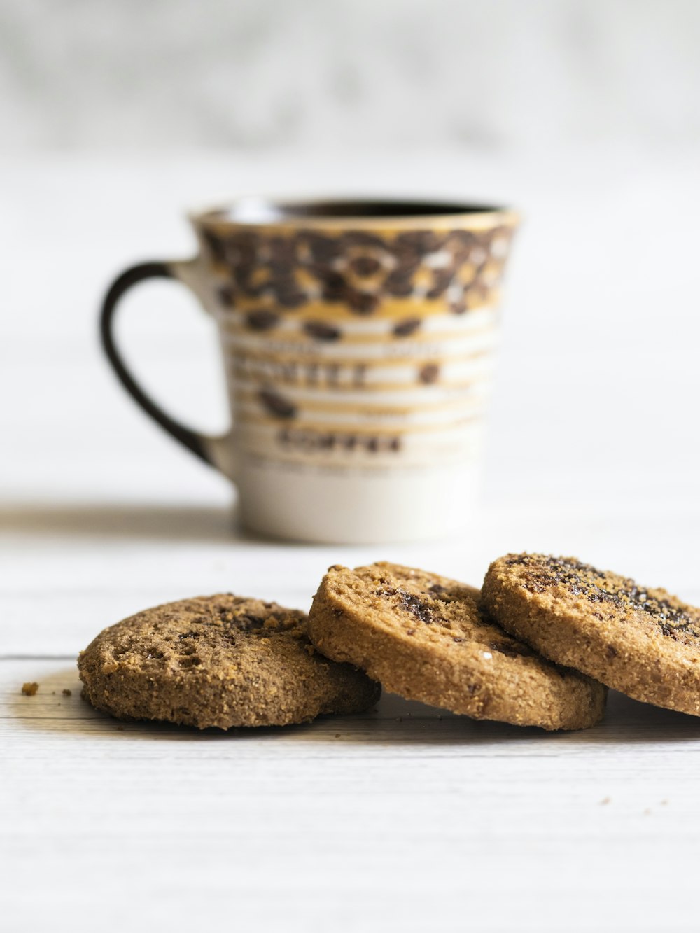 a stack of cookies next to a cup of coffee