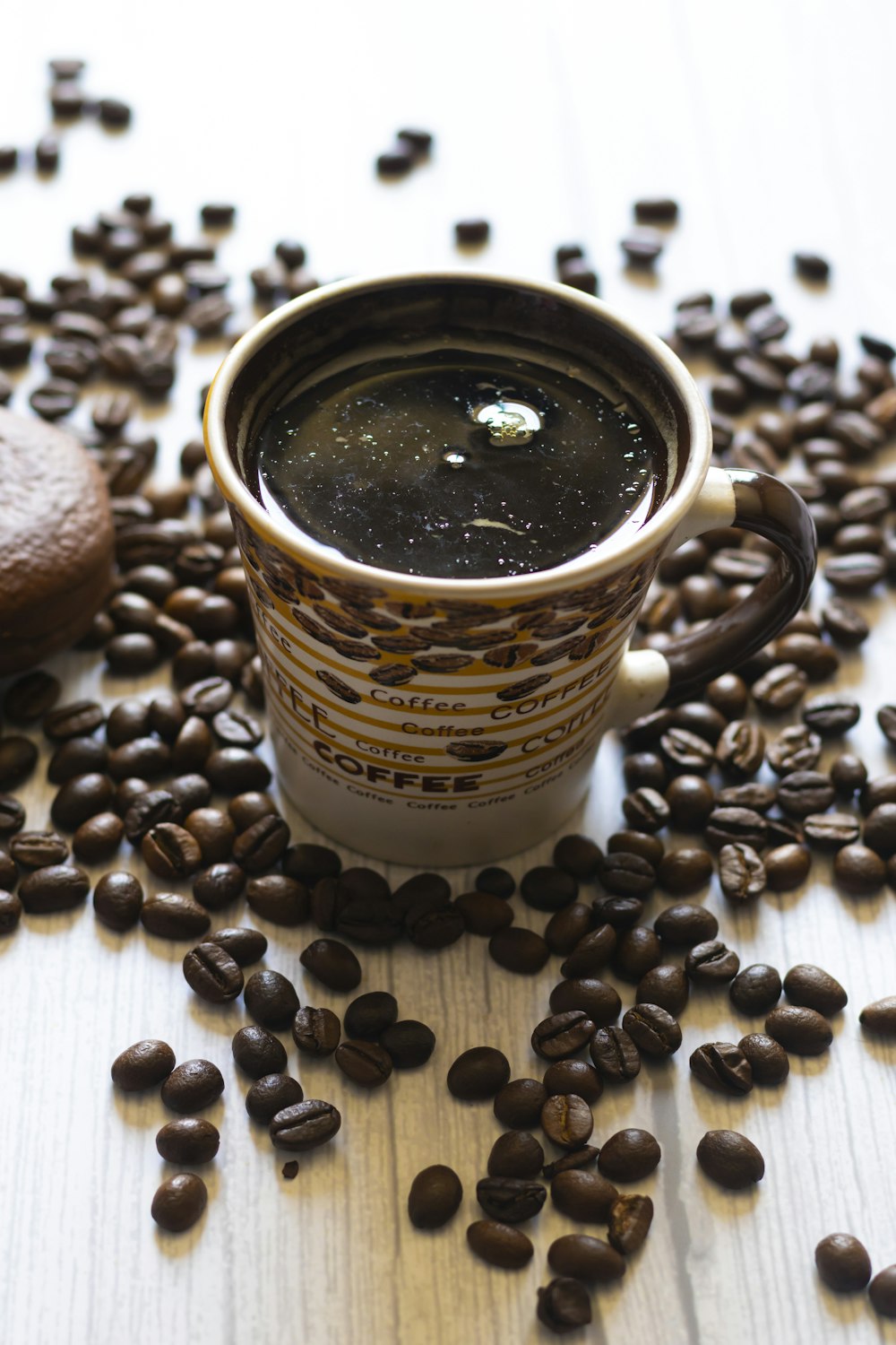 a cup of coffee sitting on top of a pile of coffee beans