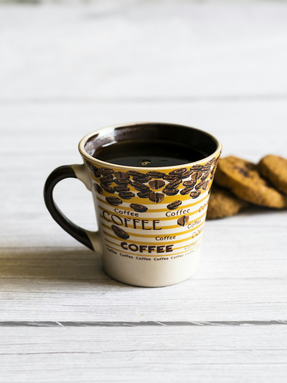 a cup of coffee next to some cookies