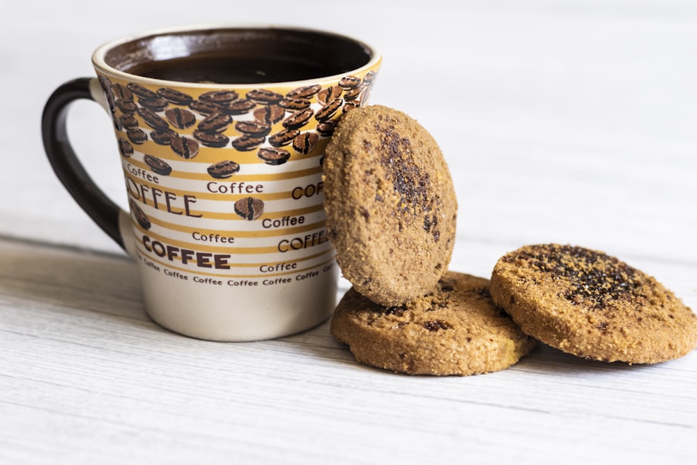 a cup of coffee and two cookies on a table