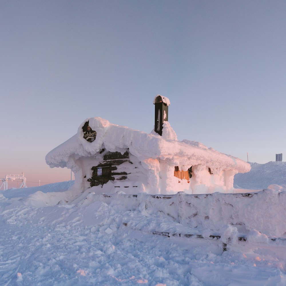 a house covered in snow with a clock on top of it