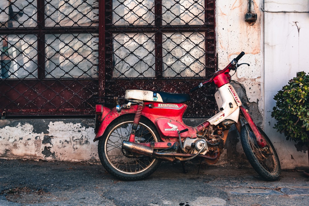 a red and white motorcycle parked in front of a building